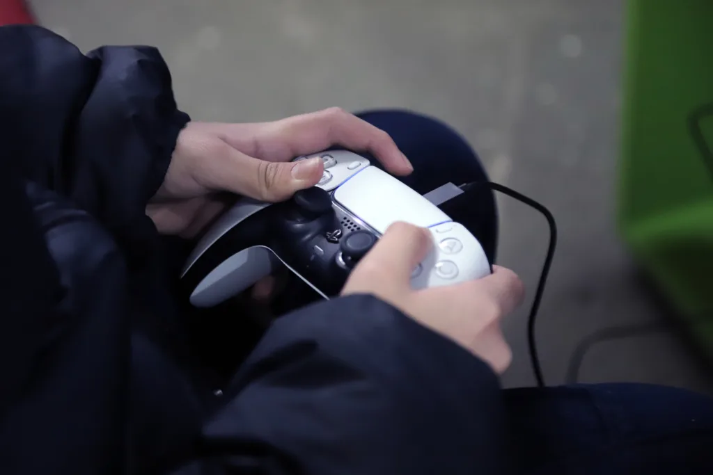 Un jugador sostiene un control de consola, símbolo de la inmersión en la cultura gamer.